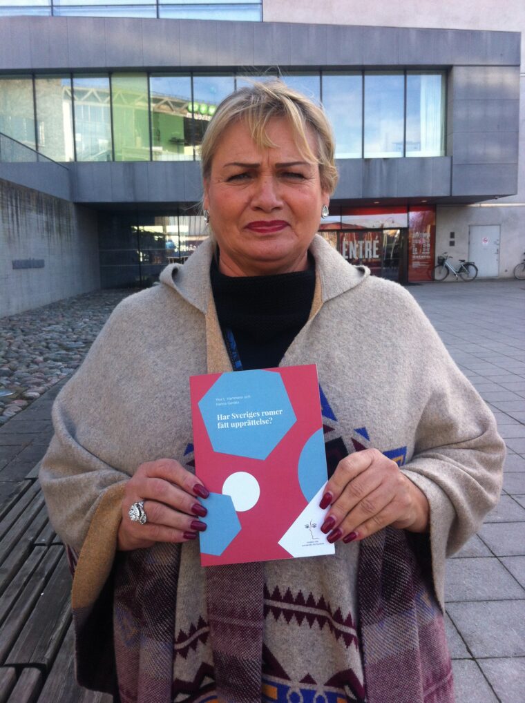 Bild på Soraya Post, EU-parlamentariker, med MR-Fondens skrift: "Har Sveriges romer fått upprättelse?" från 2015.